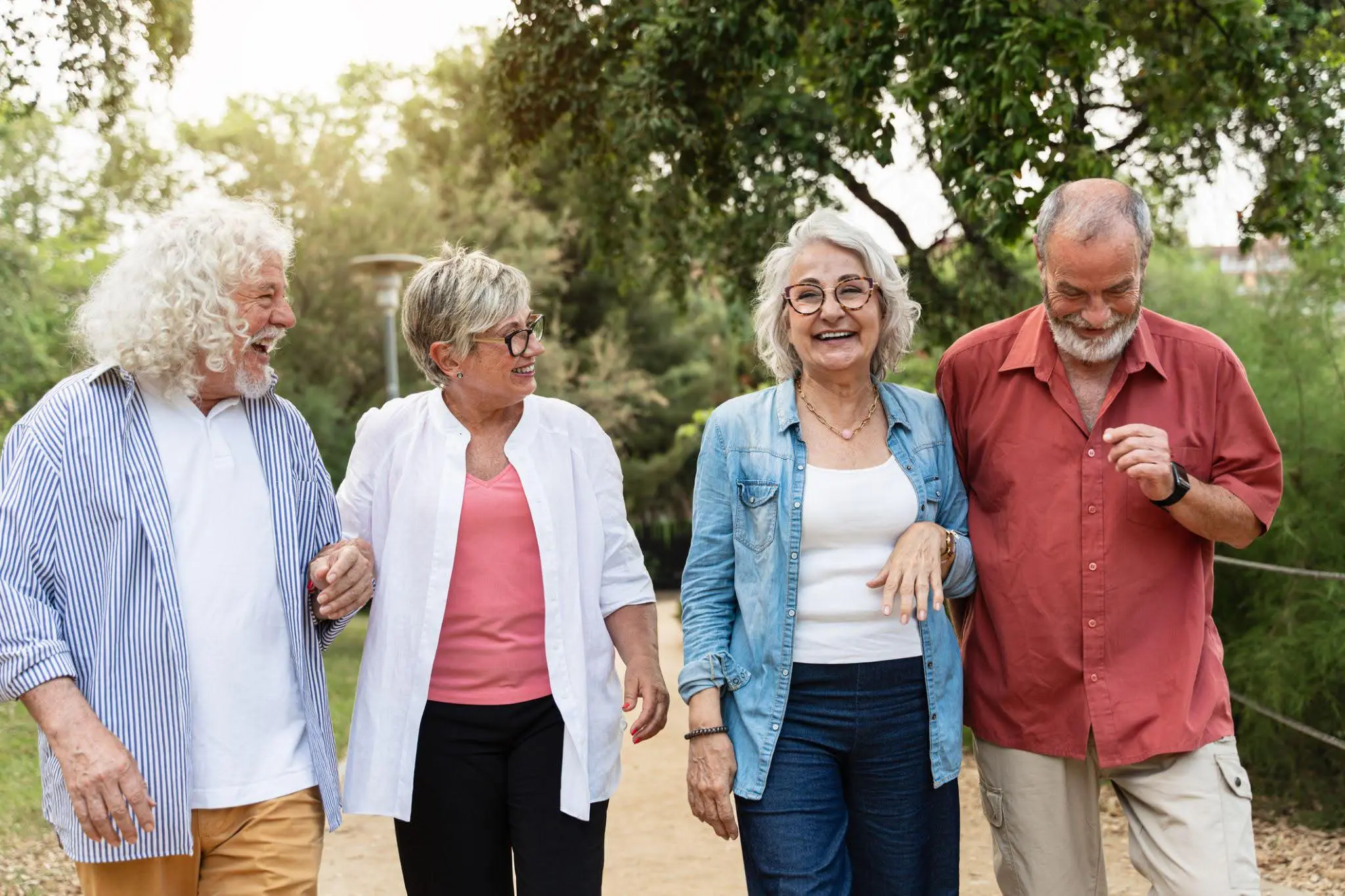 4 seniors smiling, walking and talking about joining the senior living waitlist at Kendal on Hudson, a highly sought-after senior community in Sleepy Hollow, NY.
