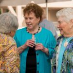 Three women talking at a social event