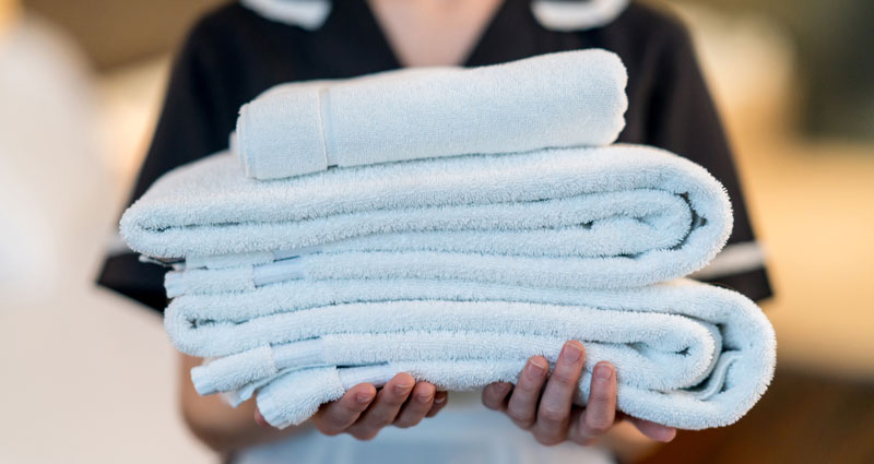 person carrying stack of towels
