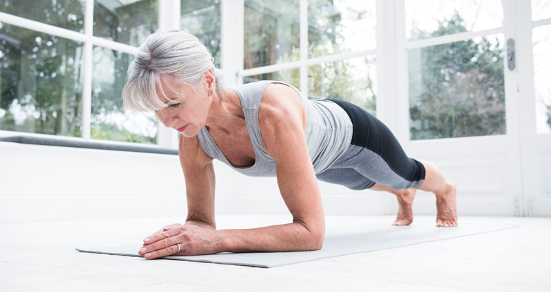 woman doing a plank on a yoga mat