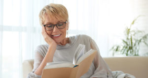 Woman reading book lounging on a sofa