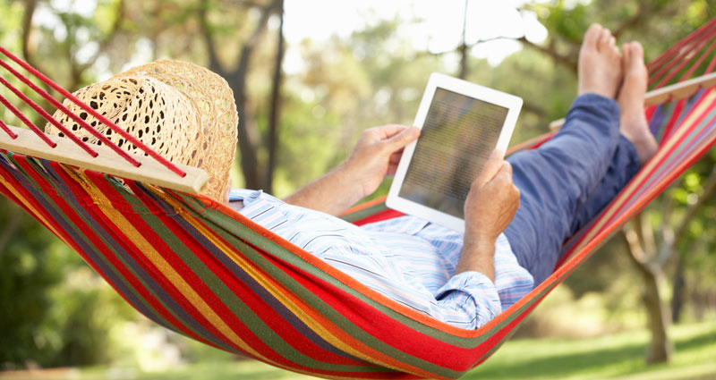 person in hammock reading a tablet