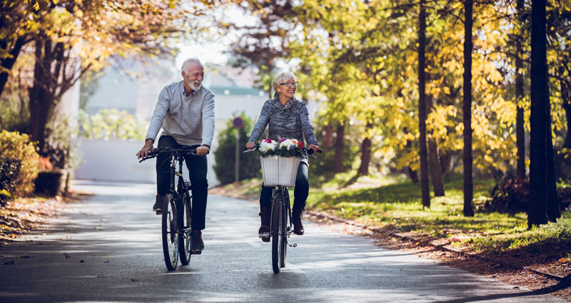 Two people riding bikes on a fall day