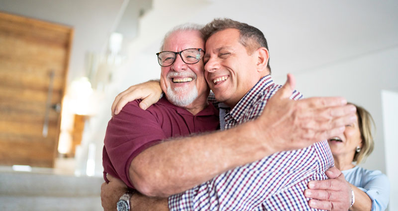 Older man embracing younger man