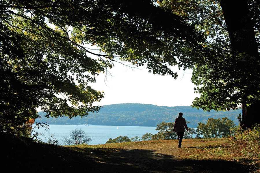 Person walking a nature path in front of the Hudson River