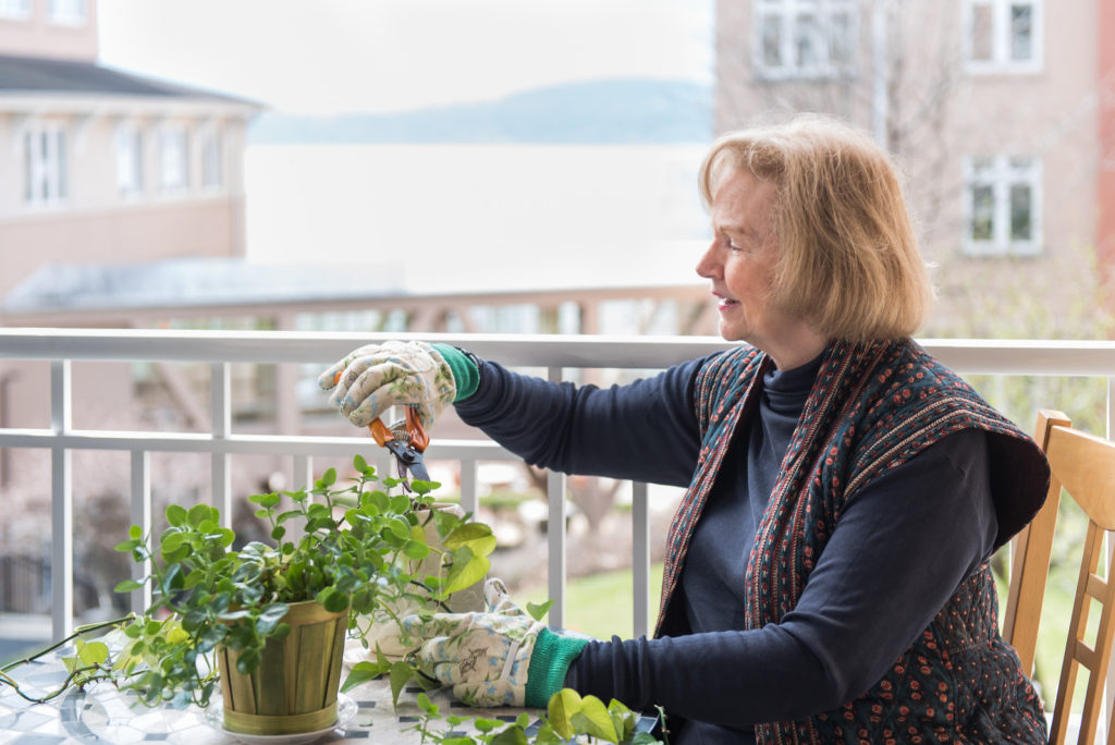 Resident pruning a plant on her balcony