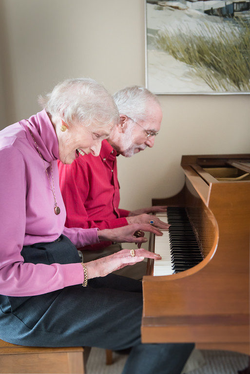 man and woman playing together on the piano