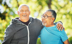 Portrait, friends and senior men in fitness hug at park outdoor after exercise, workout or training together for healthy body. Face, smile and elderly people embrace for teamwork, trust and support