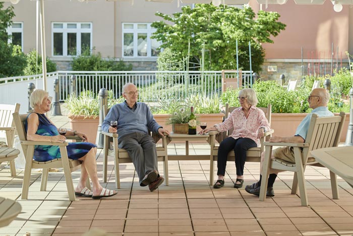 seniors sitting outside under a covered porch
