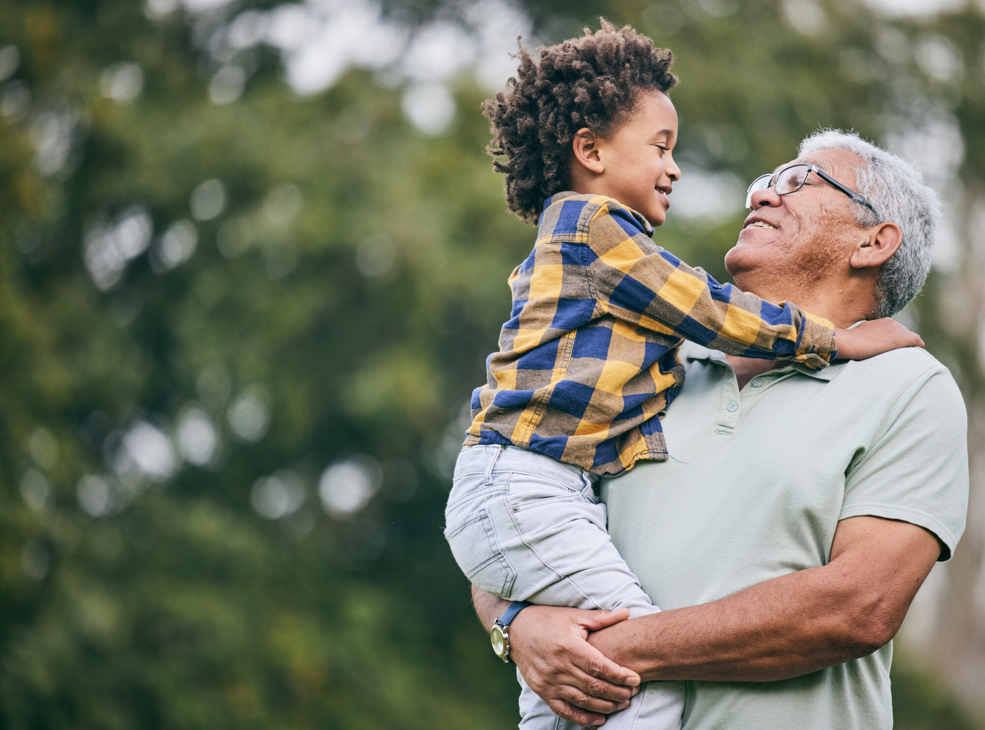 Grandparent holding their grandchild outside