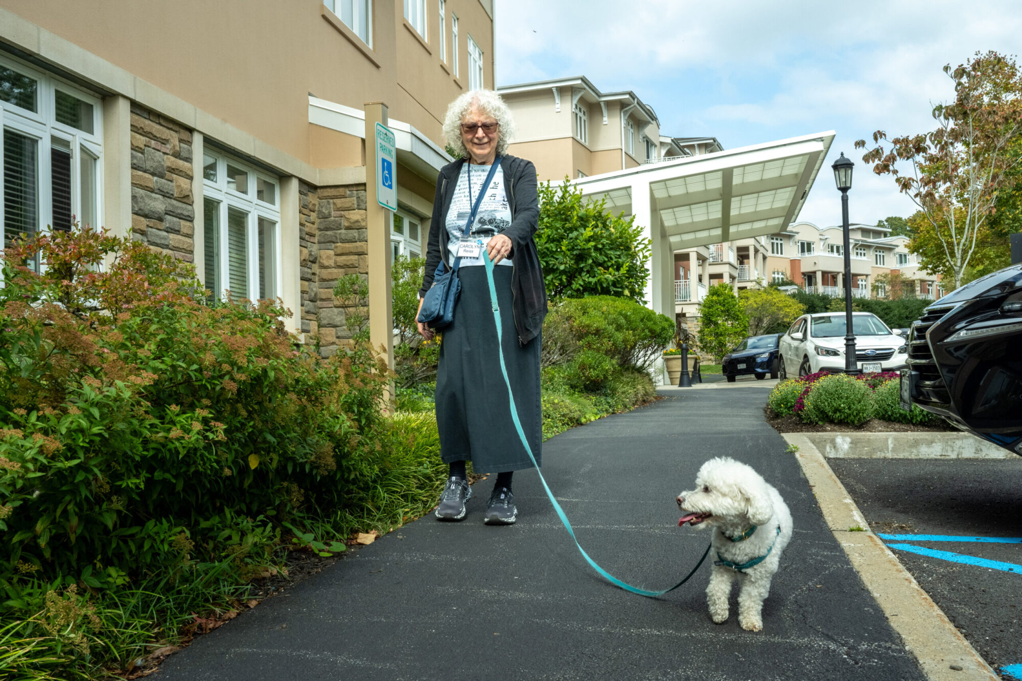 senior woman at Kendal on Hudson walking her white dog
