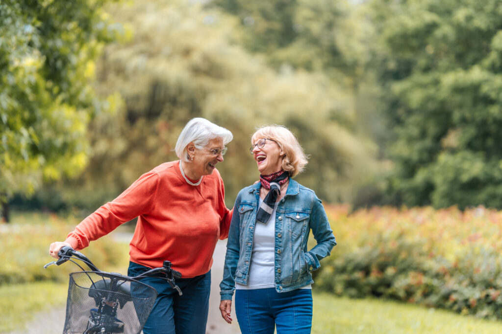 two senior woman laughing on bike path