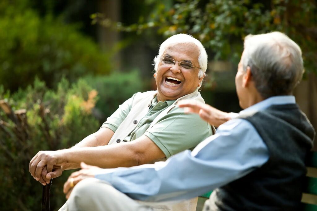 senior men sitting on bench and laughing