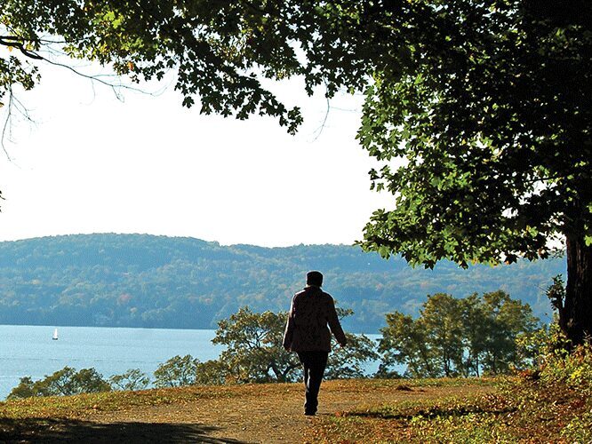 Person walking outside with Hudson River in the background