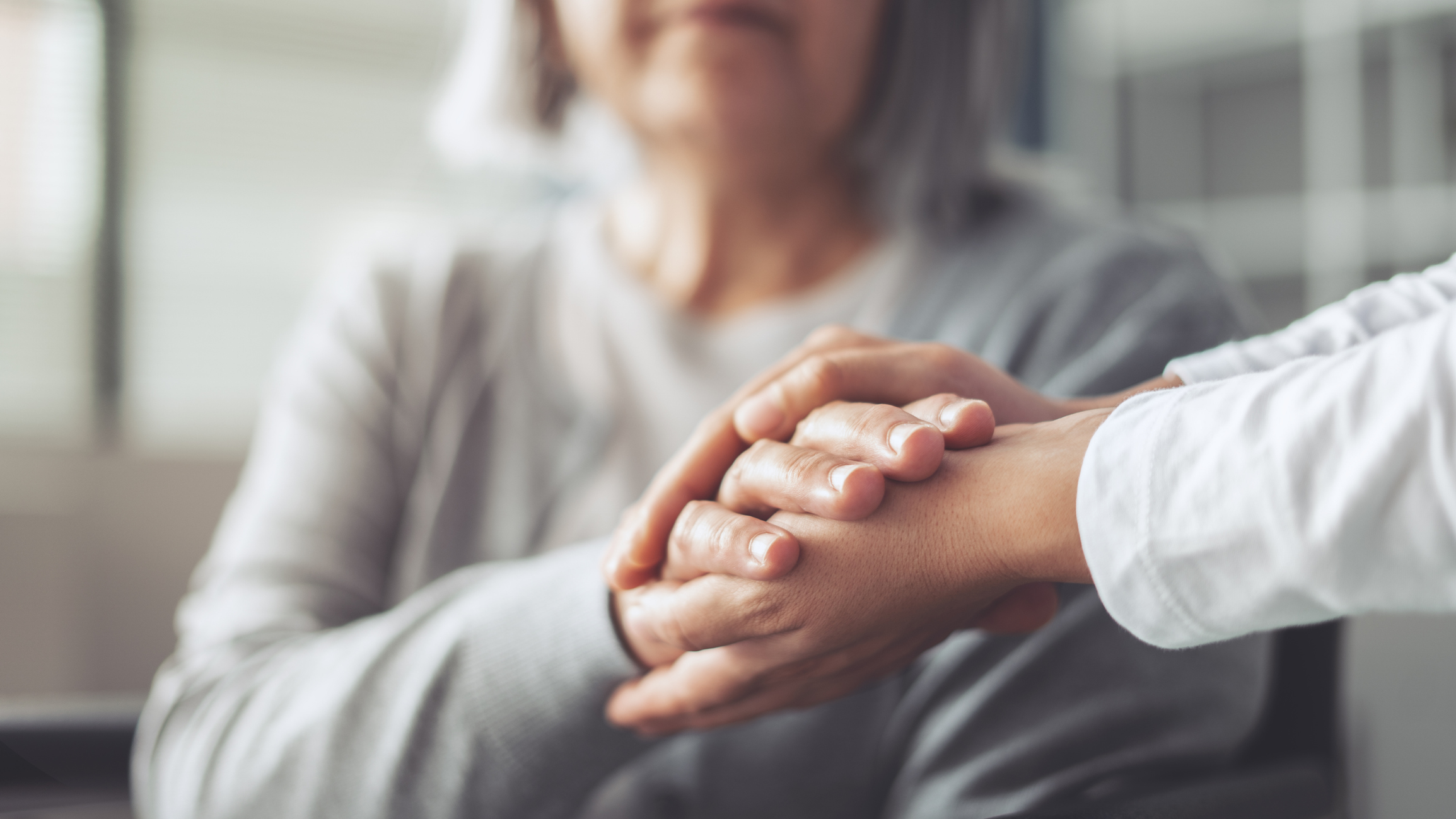 senior holding hand of caregiver
